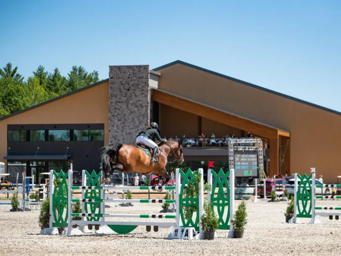billie-derouet-in-front-indoor-ring-with-cafe-bistro-l_equestria-and-terrasse-copie-scaled